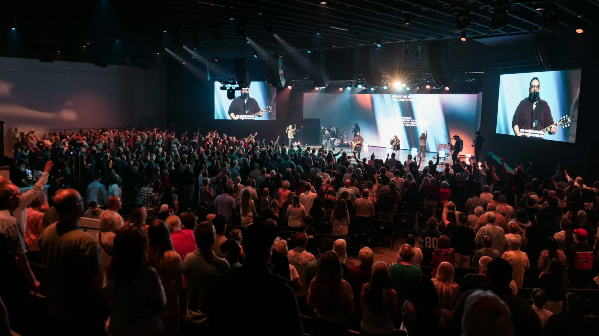 A congregation worshipping together in a large room