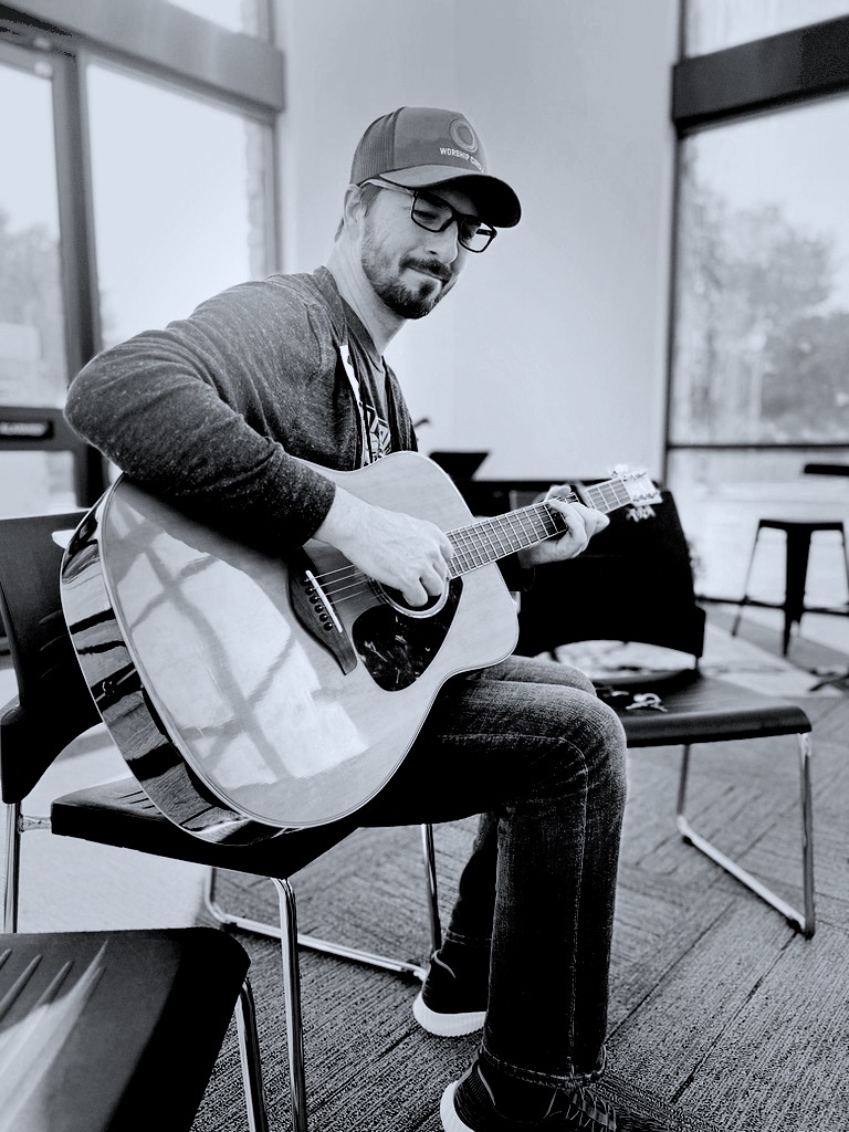 Jay Kent, founder of Refined, playing acoustic guitar